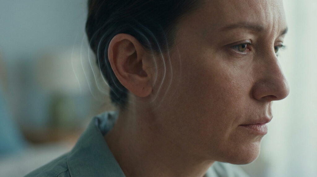 Femme pensive avec des ondes sonores graphiques autour de l'oreille.